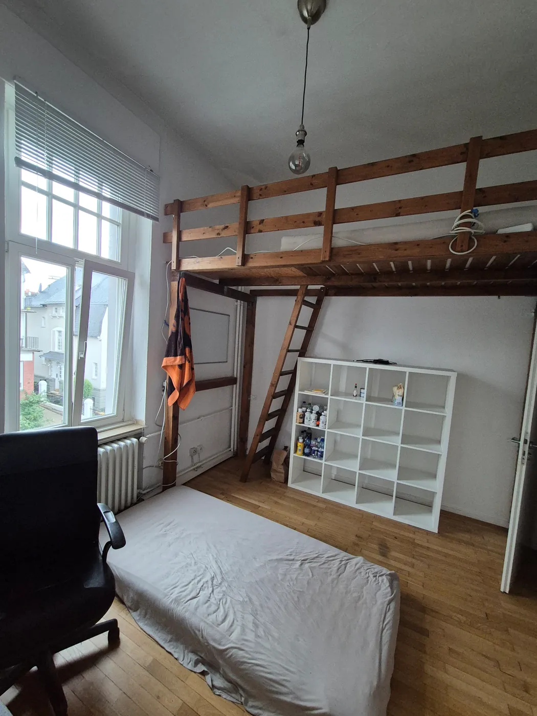 Zimmer mit Hochbett aus Holz und Regal
