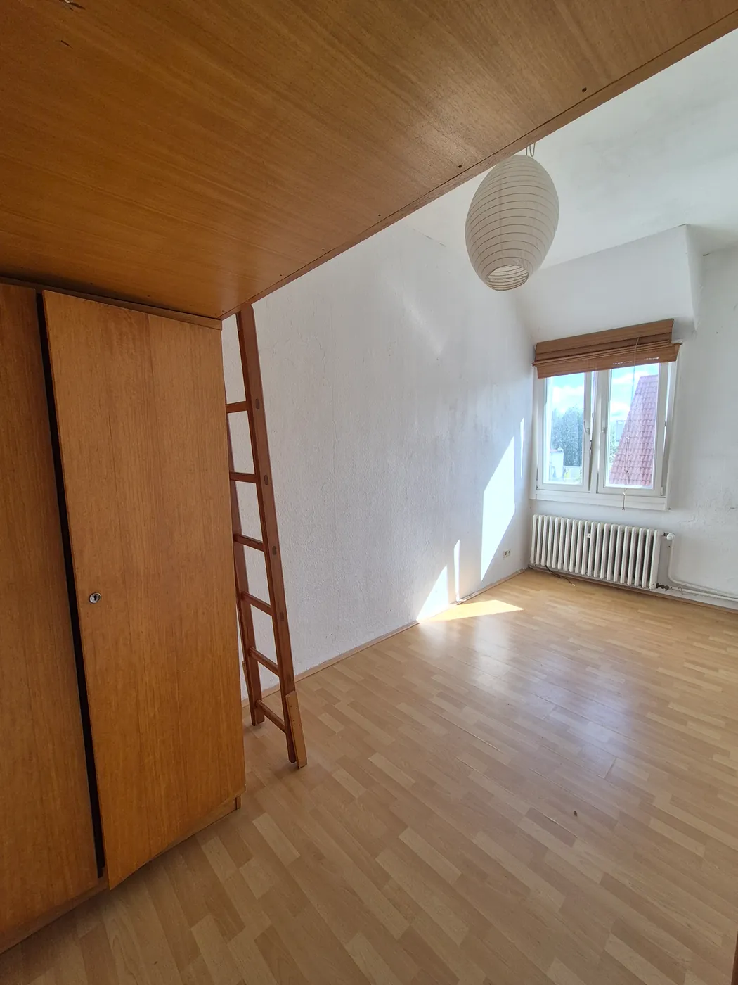 Zimmer mit Holzdecke und Einbauschrank