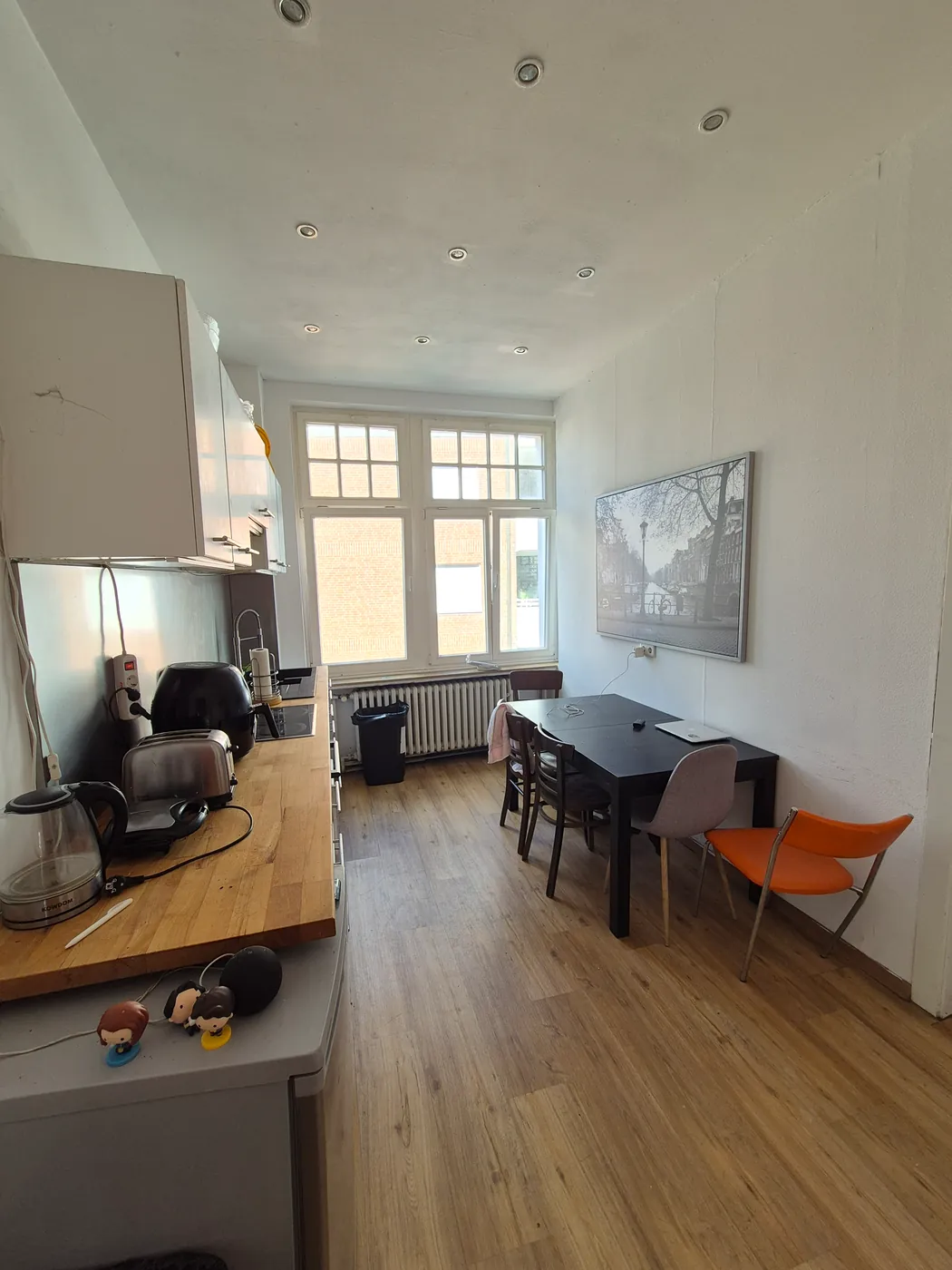 Wohnküche mit langem Tisch und Fenster zum Hof